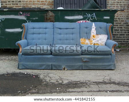 Vintage old grungy ripped abandoned couch left for garbage