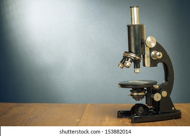 Vintage old microscope on table for science background