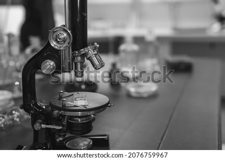 Vintage old microscope on table for science background. Medicine, alchemy, pharmacist. glass jars, flasks and tools, Selective focus.