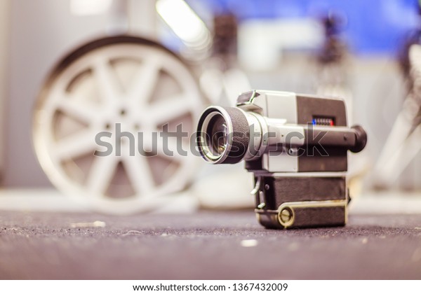 Vintage old movie camera, production studio in\
the blurry background