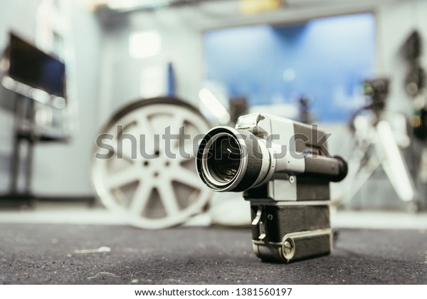 Vintage old movie camera, production studio in\
the blurry background