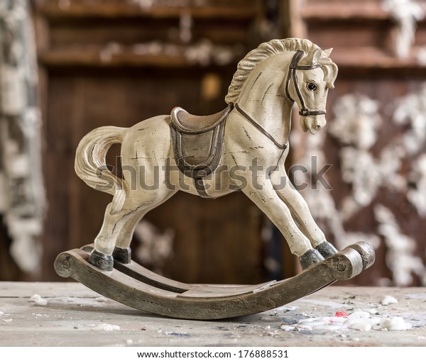 Vintage old\
rocking horse on a wooden\
background