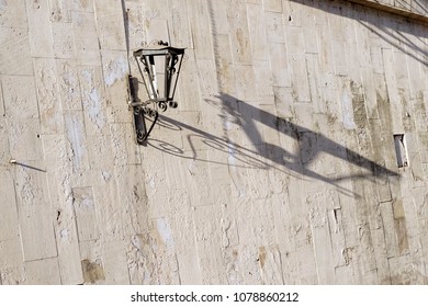 Vintage Old Street Classic Iron Lantern On The House Wall, Close Up. Streetlight Broken With Long Shadow