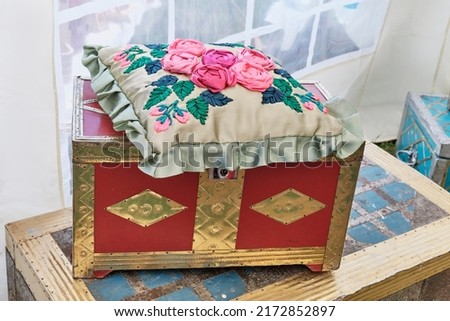 Vintage old Tatar traditional chests and small pillow with floral pattern, embroidered colorful ribbons. Folk festival Sabantuy