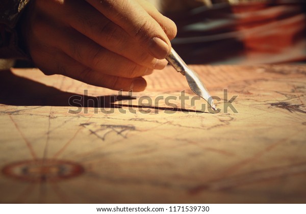 Vintage old treasure  map, pen in the hands of\
cartographer, map\
drawing