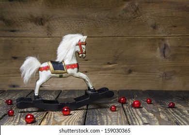 Vintage - Old Wooden Rocking Horse On A Wooden Old Board For A Christmas Card With Red Balls - Classic Decoration