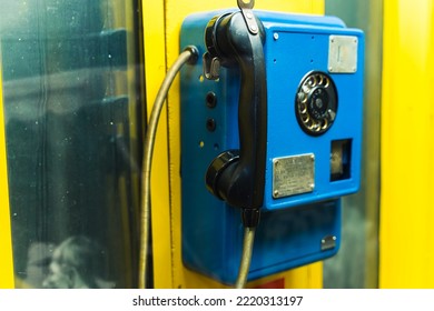 Vintage Old-fashioned Bright Yellow Phone Booth With Dark Blue Telephone Set. The Evolution Of Technology And Communication Systems. High Quality Photo