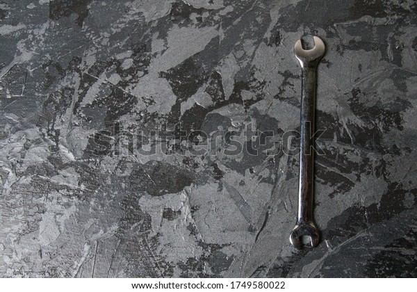 Vintage open end wrench on dark gray background\
with place for text.