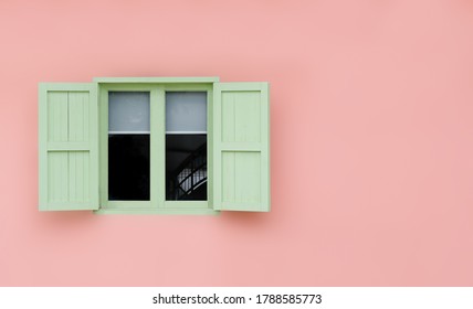 Vintage opened green mint shutters and wooden windows isolated on pink background with copy space and clipping path.
