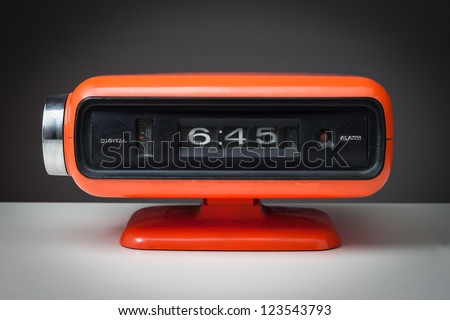 Vintage orange alarm clock on a dark background