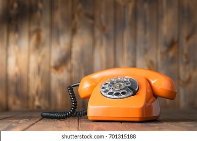 Vintage Orange Phone On A Wooden Table