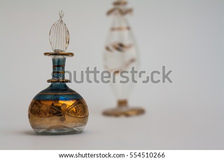 Vintage parfum bottles, blue and transparent glass containers decorated  in gold, empty, isolated on blank background. 