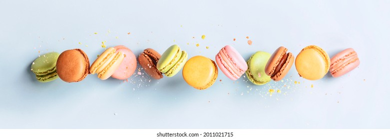 Vintage Pastel Colored French Macaroons Or Macarons In Motion Falling On Light Blue Background.Food Banner Macaron Sweets