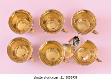 Vintage patterned teacups with a golden center on a pink background. One of them is broken. Top view, copy space. - Shutterstock ID 2143055939