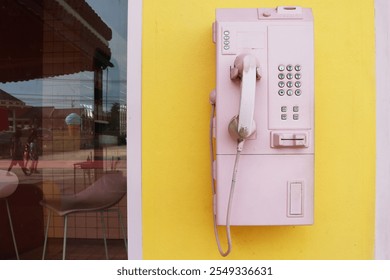 Vintage Payphone pink pastel color on yellow wall. - Powered by Shutterstock