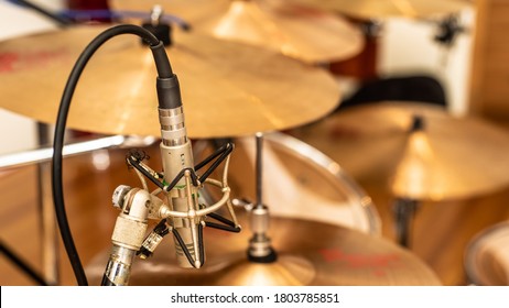 A vintage pencil microphone in place for recording drums in a recording studio setting