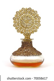 Vintage perfume bottle with gold filigree top and amber colored liquid.