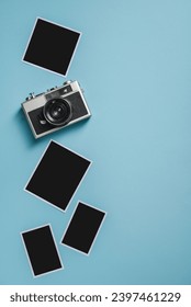 Vintage photo camera and empty photo frames on blue background. Travel moment concept