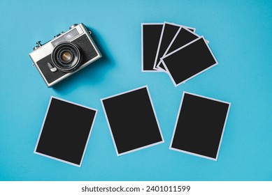 Vintage photo camera and empty photo frames on blue background. Travel moment concept