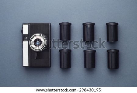 Vintage Photo Camera and photo film rolls well organized over dark blue background, above view