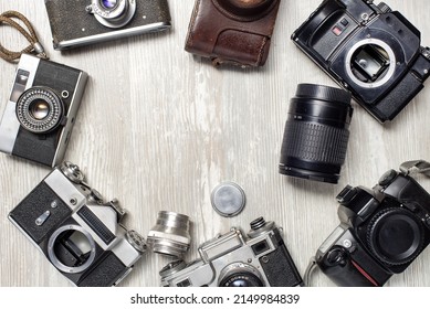vintage photo cameras and lenses on a white table. View from above. Space for text.