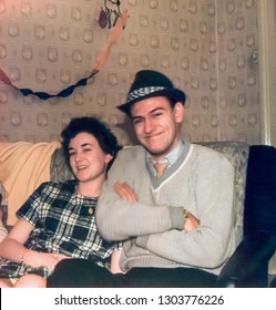 Vintage photo circa 1961 of young happy couple relaxing in a domestic living room. From a 35mm slide.
