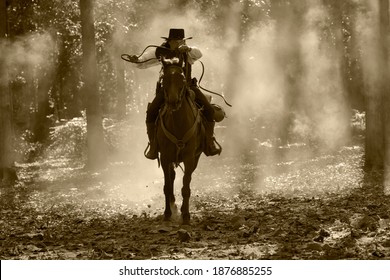 Vintage Photo Of A Cowboy Man. Ride A Horse And Shoot A Rifle In A Forest