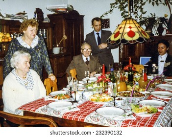 Vintage photo of elderly woman and her family during a Christmas dinner, eighties