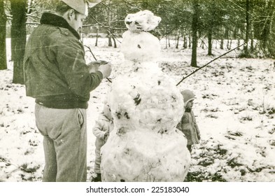 Vintage Photo Of Father With Daughter Building A Snowman, Early Eighties