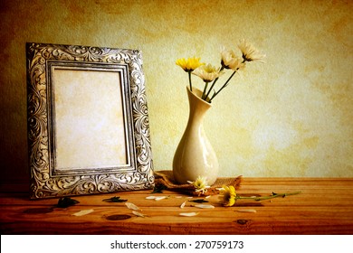 Vintage Photo Frame And Flowers On Wooden Table Over Grunge Background, Still Life Style 