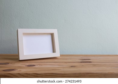 Vintage Photo Frame On Wooden Table Over Grunge Background, Still Life Style