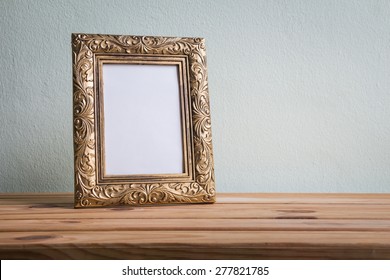 Vintage Photo Frame On Wooden Table Over Grunge Background