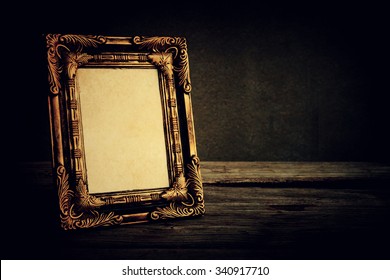 Vintage Photo Frame On Wooden Table Over Grunge Background