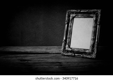 Vintage Photo Frame On Wooden Table Over Grunge Background, Black And White