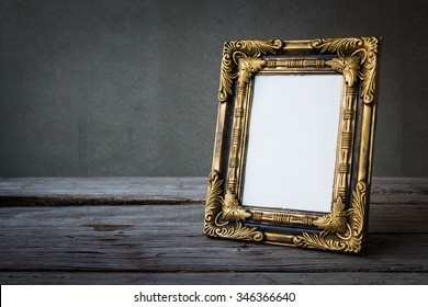 Vintage Photo Frame On Wooden Table Over Grunge Background