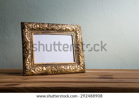 Vintage photo frame on wooden table over grunge background