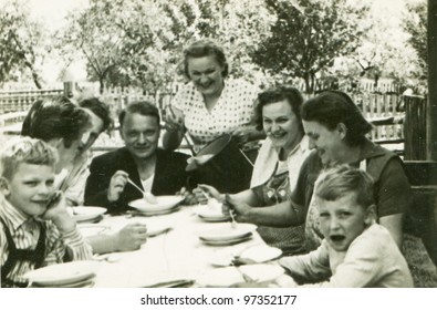 Vintage photo of happy family dining outdoor (fifties)