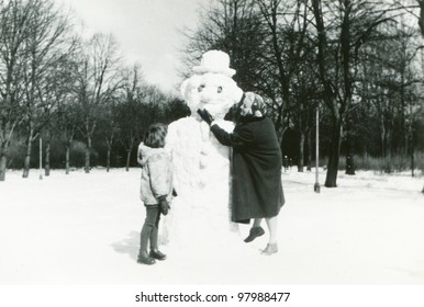 Vintage Photo Of Mother And Daughter Building A Snowman (fifties)