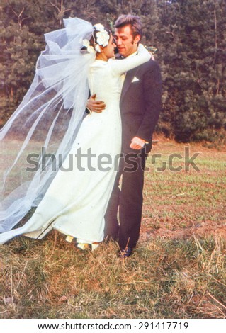 Vintage photo (scanned reversal film) of newlyweds kissing outdoor, early 1970's