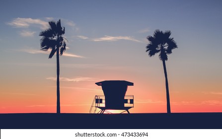 Vintage photo of a silhouette of a  Lifeguard tower on the beach at sunset with palm trees  - Powered by Shutterstock