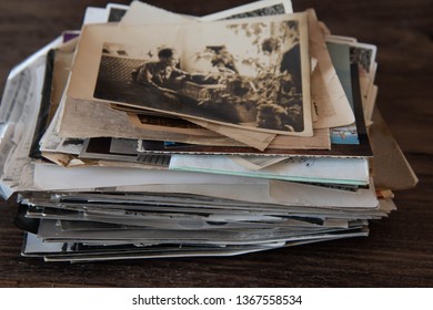 Vintage photo stack, old family photos on a dark wooden background. Memoirs