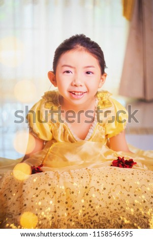 Vintage photography style of pretty Asian girl portrait in golden or yellow princess style costume, selected focus.