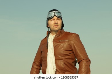 Vintage Pilot With Leather Cap, Scarf And Aviator Glasses  - Portrait Of A Man In Historical Pilot Clothing