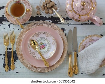 Vintage Pink China Dinner Plates, Tea Cup, Teapot, Gold Cutlery Flatware, Sugar Cubes In Crystal Bow, Wedding Tea Party Overhead View, On Distressed Wood Table