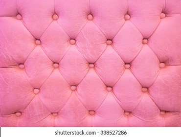 Vintage pink leather upholstery buttoned sofa (background)