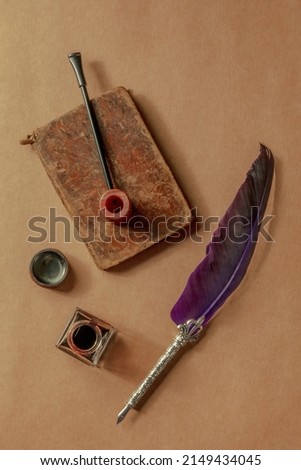 A vintage pipe with a quill pen and a notebook, overhead flat lay shot. Detective game objects