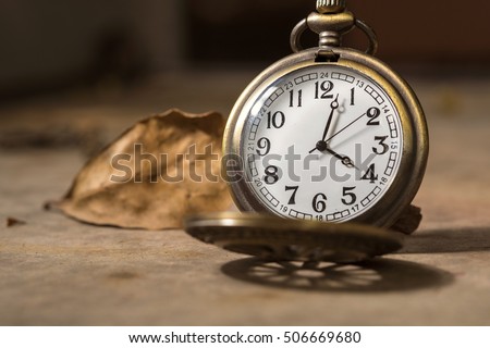 vintage pocket watch with Dry leaf background for time concept