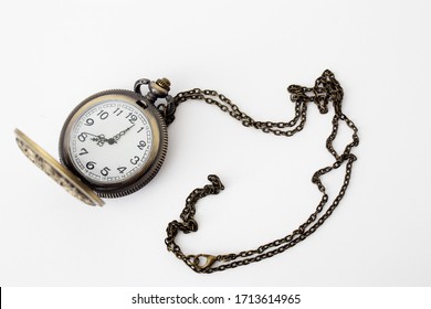 Vintage pocket watch on a chain on a white background. Copy space.