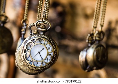 Vintage pocket watchs hanged with chains in an antique shop