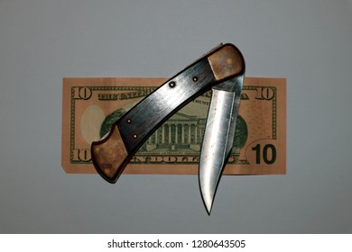 A Vintage Pocketknife Laying On Top Of The Back Of An American Ten Dollar Bill